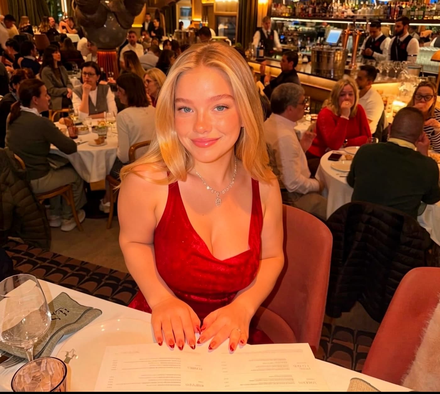 Yuna am Tisch in einer Pariser Brasserie, die Karte vor sich