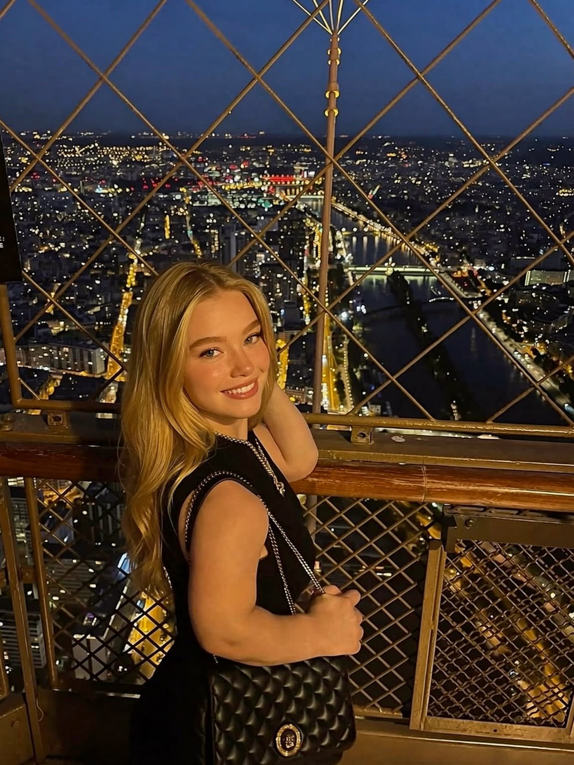 Yuna oben auf dem Eiffelturm, dahinter das beleuchtete Paris
